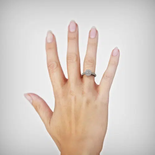 Anillo de compromiso AELLO en oro blanco 18k Fairmined o platino responsable 950 con diamante de 25 o 30 puntos, mostrado en una mano femenina