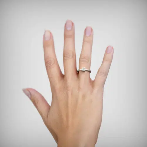 Anillo de compromiso AQUA en oro blanco 18k Fairmined o platino responsable 950 con diamante de 30, 50 o 100 puntos, mostrado en una mano femenina, origen laboratorio