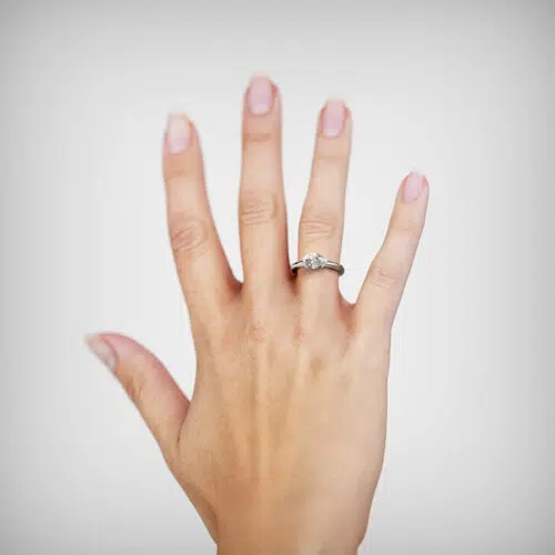 Anillo de compromiso AURIS en oro blanco 18k Fairmined o platino responsable 950 con diamante de laboratorio en una mano femenina