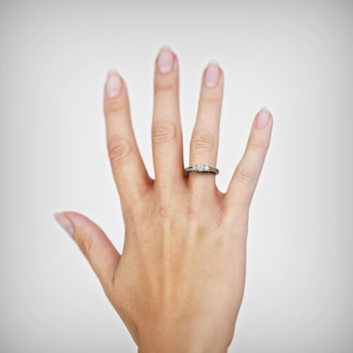 Anillo de Compromiso Tricillo Ember Oro Blanco 18kt Anillo de compromiso EMBER en oro blanco 18k Fairmined o platino responsable 950 con diamante de 20 o 30 puntos, mostrado en una mano femenina