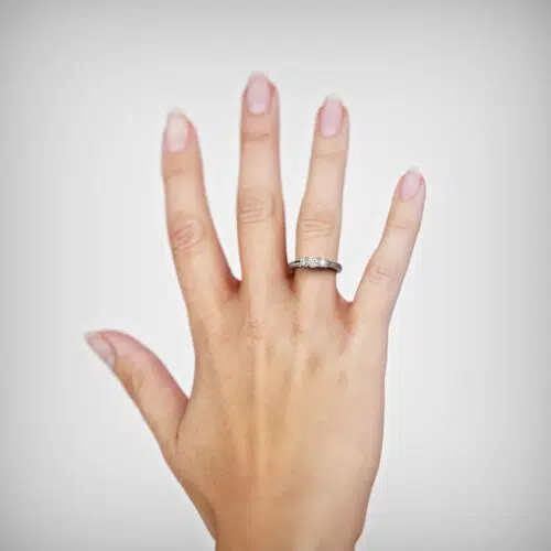 Anillo de compromiso EMBER en oro blanco 18k Fairmined o platino responsable 950 con diamante de 20 o 30 puntos, mostrado en una mano femenina