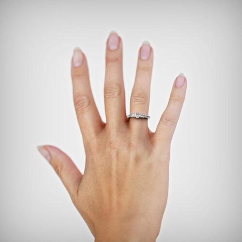 Anillo de Compromiso Tricillo Ignis Oro Blanco 18kt Anillo de compromiso IGNIS en oro blanco 18k Fairmined o platino responsable 950 con diamante de 30 o 40 puntos, mostrado en una mano femenina