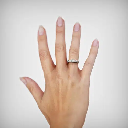 Anillo de compromiso LUCERI en oro blanco 18k Fairmined o platino responsable 950 con diamante de 40 o 50 puntos, mostrado en una mano femenina