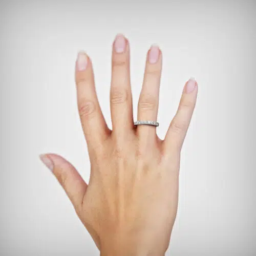 Anillo de compromiso LUCIDA en oro blanco 18k Fairmined o platino responsable 950 con diamante de 5 puntos, mostrado en una mano femenina