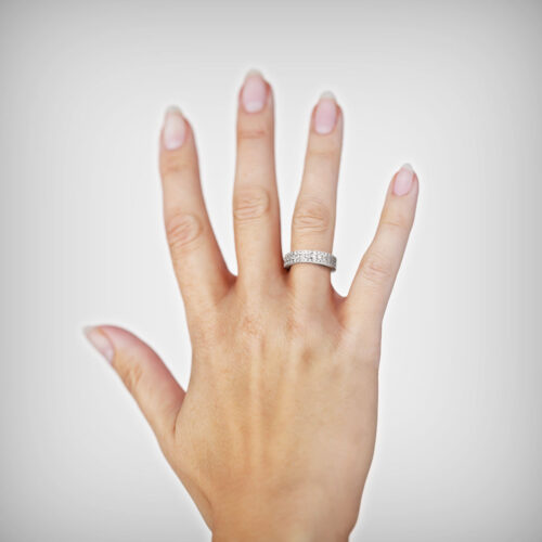 Anillo de Compromiso Cintillo Nefeli Oro Blanco 18kt Anillo de compromiso NEFELI en oro blanco 18k Fairmined o platino responsable 950 con diamante de 3 puntos, mostrado en una mano femenina