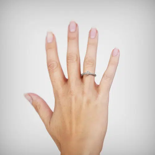 Anillo de compromiso STELYS en oro blanco 18k Fairmined o platino responsable 950 con diamante de 30 o 40 puntos, mostrado en una mano femenina