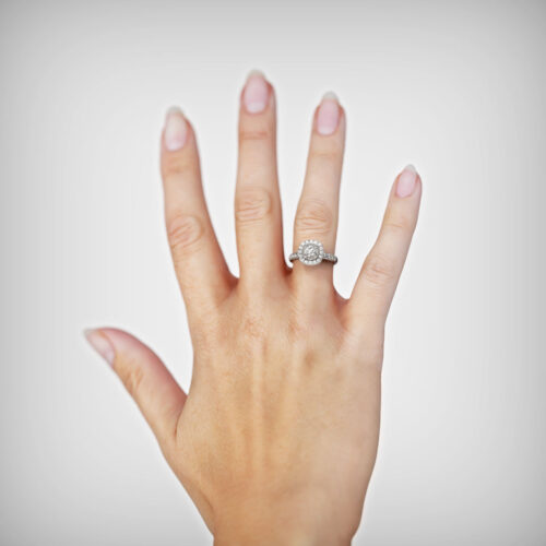 Anillo de Compromiso Halo Tempes Oro Blanco 18kt Anillo de compromiso TEMPES en oro blanco 18k Fairmined o platino responsable 950 con diamante de 40 o 50 puntos, mostrado en una mano femenina