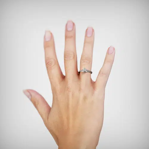 Anillo de compromiso UNDA en oro blanco 18k Fairmined o platino responsable 950 con diamante de laboratorio, mostrado en una mano femenina